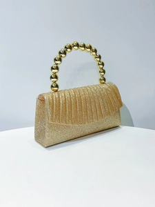 Detail of gold glitter clutch with beaded handle and elegant pleated texture