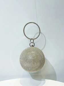Macro shot of sphere evening clutch with shimmering rhinestones and metal ring handle
