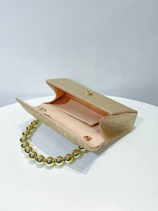 Interior view of gold glitter evening clutch with pearl handle and satin lining