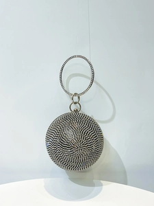 Macro detail of round spherical evening clutch with silver rhinestones and metal handle