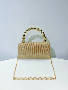 Close-up of golden pleated evening clutch bag with sequin finish and pearl bead handle