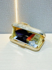 Interior detail of golden glitter clutch showing space for lipstick and essentials