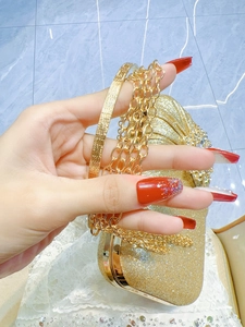 Detail of glitter evening clutch featuring sparkling rhinestones and a gold metal chain