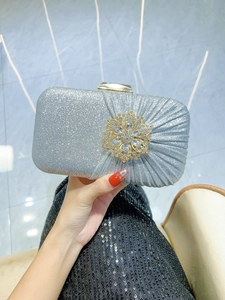 Detail of silver sequin evening clutch bag with crystal gold flower buckle accent