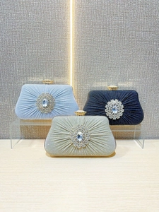 Pleated evening handbags with rhinestone flower clusters in black, blue, and champagne