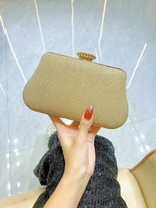 Detailed macro view of the gold rhinestone clutch with elegant pleated surface