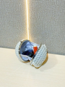 Close-up of spherical pearl evening bag showing luxury beaded surface and satin interior