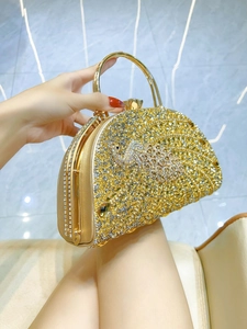 Luxurious evening clutch bag with gold and silver rhinestones and a metal ring handle