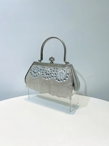 Detail of silver evening bag with rhinestone floral clusters and long tassels
