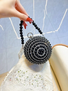 Detail of spherical black evening bag featuring pearl beads and sparkling rhinestones