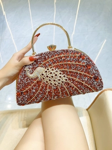 Detailed close-up of a semi-circular evening clutch featuring a jeweled peacock design