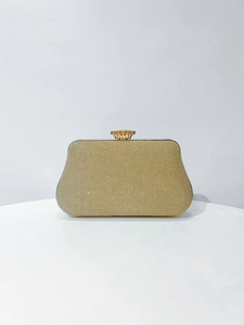 Detail view of golden glitter evening clutch with crown clasp for wedding party