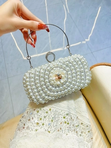 Detail of luxury pearl evening clutch bag with 3D flower and crystal metal handle