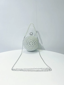 Detail view of spherical pearl evening bag with metallic chain and elegant pearl handle