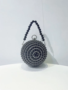 Detail of spherical evening clutch with black pearls and sparkling silver rhinestones