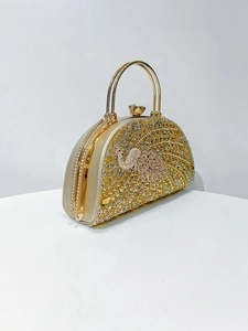 Macro detail of luxury gold evening clutch showing intricate peacock rhinestone patterns