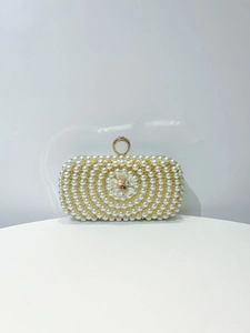 Close-up of pearl evening bag with central flower detail and rhinestone ring clasp