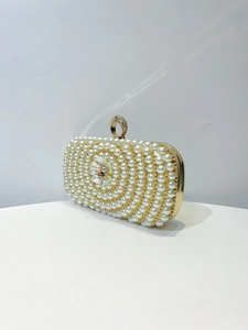Detailed macro view of an elegant evening clutch bag with pearls and floral crystal clasp