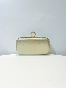 Detail of champagne gold evening bag with rhinestone ring handle and pearl trim