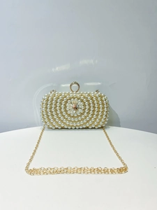Detailed view of handmade pearl evening bag with floral bead center and gold chain