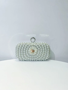 Detailed view of handmade pearl evening bag with 3D floral accent and rhinestone clasp