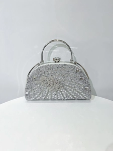 Detailed view of semi-circular silver evening clutch with sparkling rhinestones and U-handle