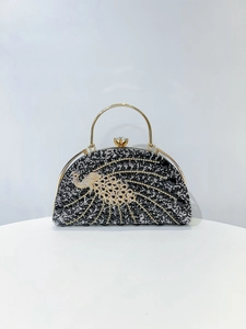 Detailed close-up of a semi-circle evening clutch bag with crystal peacock motif