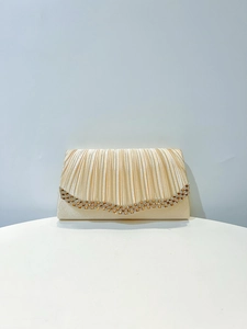Détail d'une pochette de soirée champagne en tissu plissé avec bordure en strass