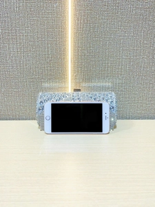 Size comparison of silver rhinestone evening clutch bag with a smartphone