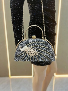 Detail of luxury evening clutch with crystal peacock design and large diamond top handle
