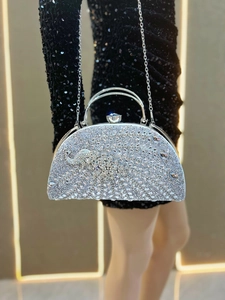 Macro view of crystal encrusted silver evening bag with ornate handle and chain