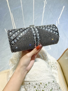 Macro view of luxurious cylindrical evening clutch bag with black and silver rhinestones