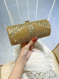Detailed macro of a gold cylinder evening bag featuring sparkling crystals and rhinestones