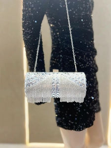 Detail of silver rhinestone evening clutch bag with sparkling tassel and metallic chain