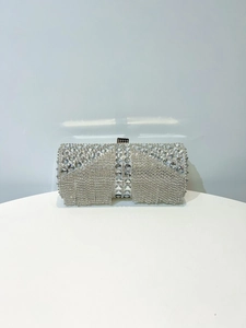 Close-up of silver evening clutch bag with sparkling rhinestones and tassel details