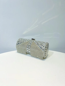 Detail of a sparkling crystal evening bag with long silver tassels on a luxury display