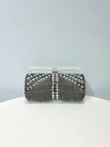 Detail view of a luxury cylindrical evening clutch with inlaid rhinestones and crystals
