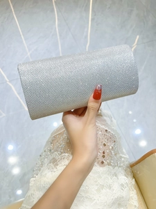 Close-up of sparkling silver sequin clutch bag paired with an elegant white lace dress