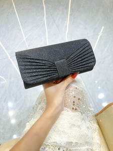 Macro detail of black glitter evening clutch with pleated design and shimmering texture