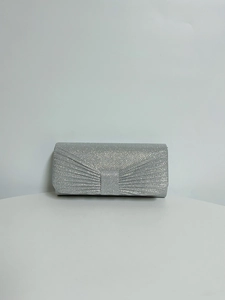 Close-up of silver sequined evening clutch bag with elegant pleated bow design detail