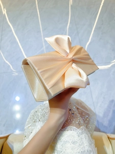 Elegant champagne satin evening clutch with large bow decoration for party occasions
