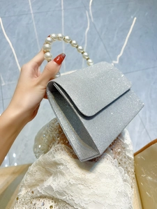 Elegant silver sequin evening clutch bag featuring a luxurious pearl and rhinestone handle
