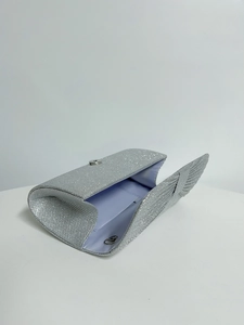 Detail of silver glitter evening clutch showing magnetic snap closure and sparkly texture