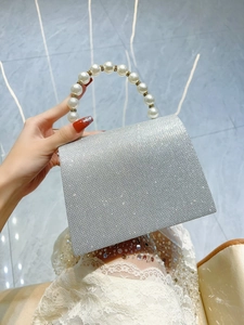 Detail of silver rhinestone evening bag with elegant large pearl beaded handle