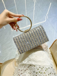 Close-up of elegant sequined evening clutch with round gold handle and sparkly finish