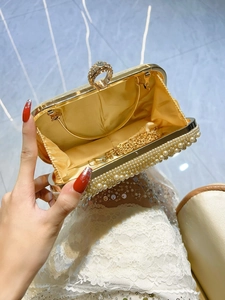 White pearl evening clutch bag with diamond ring clasp and gold chain strap for party