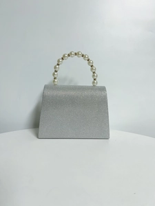 Detail of the pearly handle and glittering silver fabric on this elegant evening clutch bag