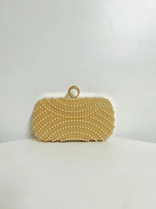 Detail of evening clutch featuring champagne pearls and a crystal-encrusted ring clasp