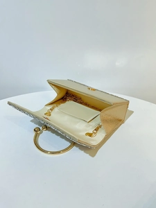 Detail view of gold evening clutch bag with sparkly crystals and detachable chain strap