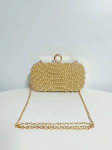 Detailed view of the champagne pearl evening bag with rhinestone buckle and gold chain